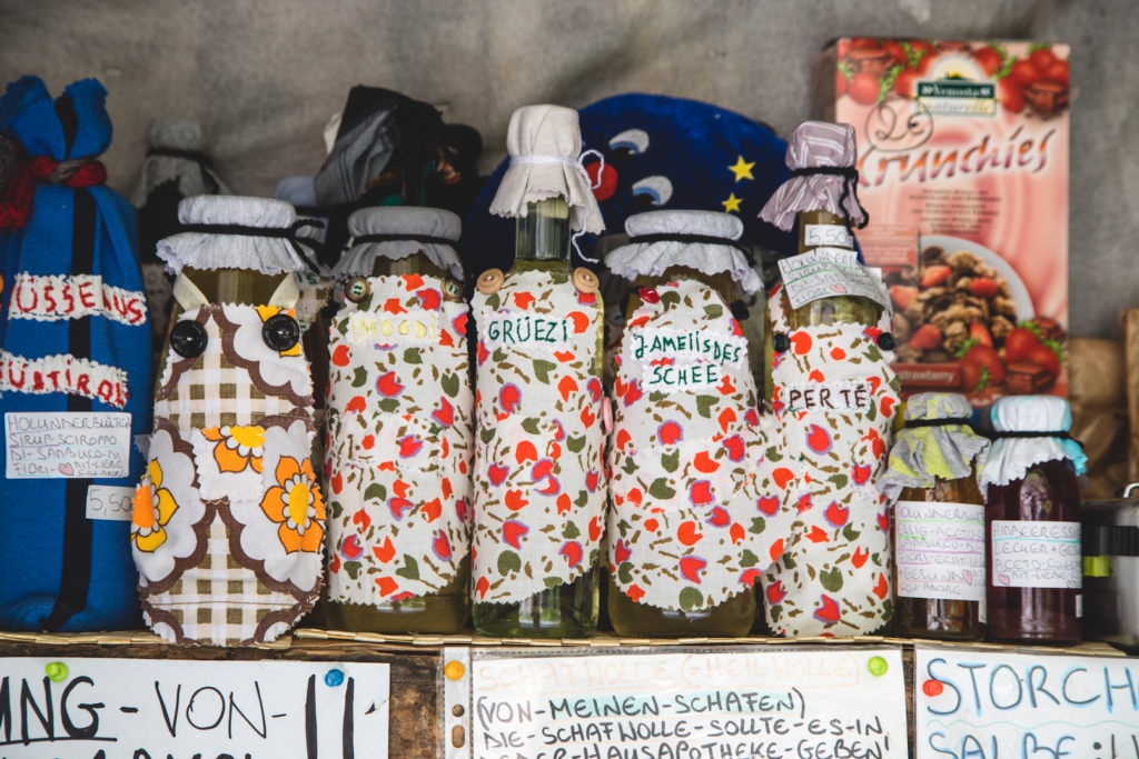 Mehrere selbstgemachte Sirupflaschen stehen in einem Regal im Hofladen bei Meran