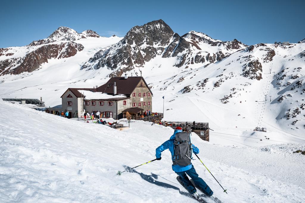 Ein Skifahrer fährt in Richtung einer Schutzhütte