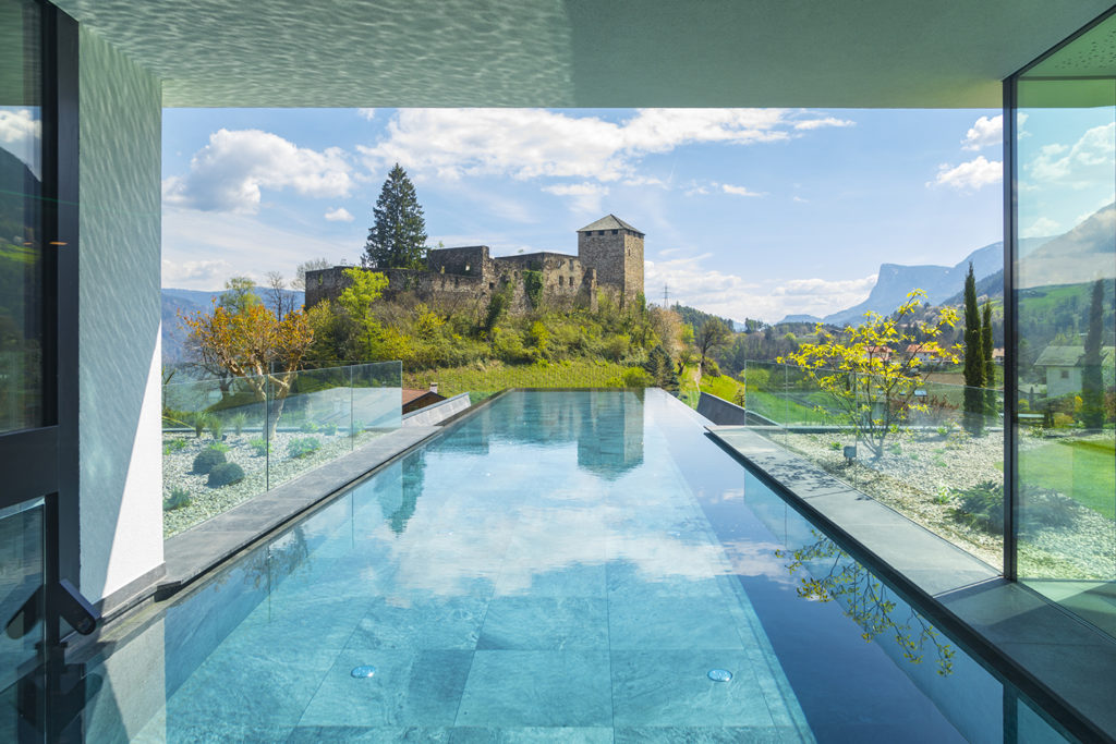 Infinitypool bei frühlingshaftem Wetter mit Aussicht auf die Burgruine Mayenburg - 10 Dinge über Südtirol